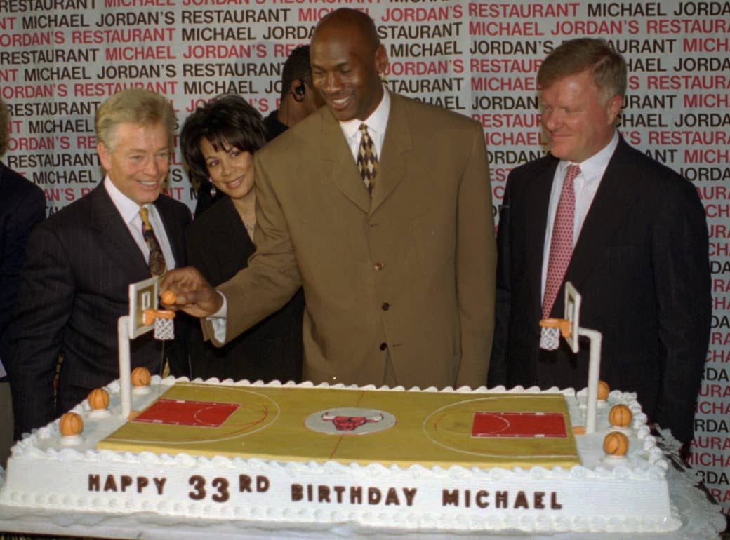 Michael Jordan dunking a basketball on his 33rd birthday cake