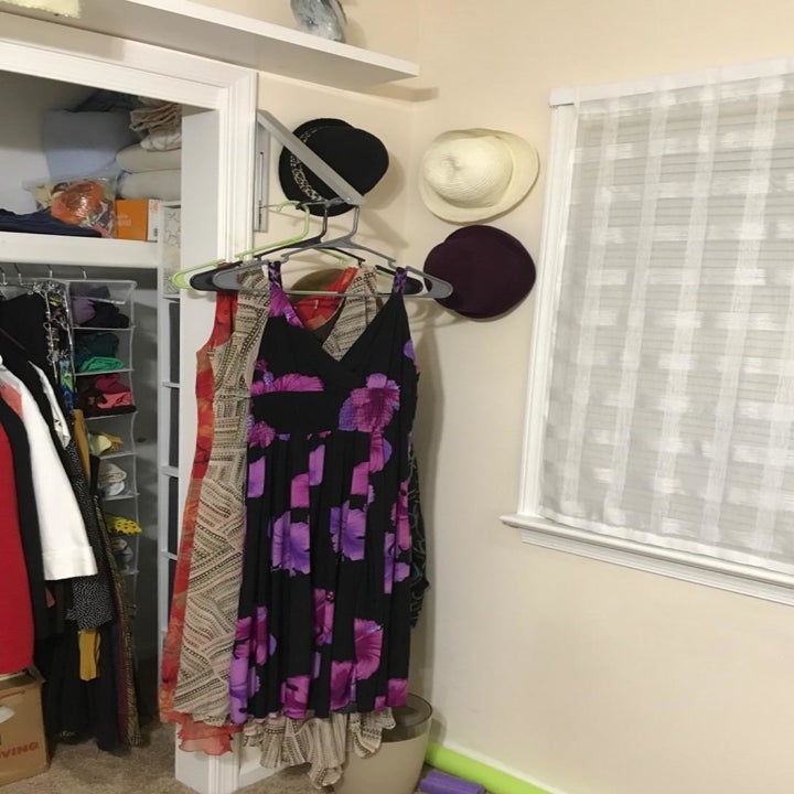 The wall mount with long dresses hung on it