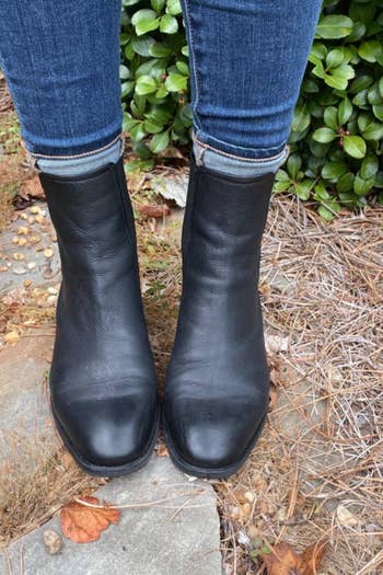 a reviewer photo of someone outside wearing jeans and the black ankle boots 