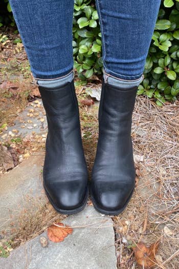 Reviewer wearing black boots outside with blue jeans