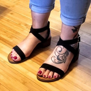 A reviewer photo of someone wearing jeans and the strappy block heel sandals in black 