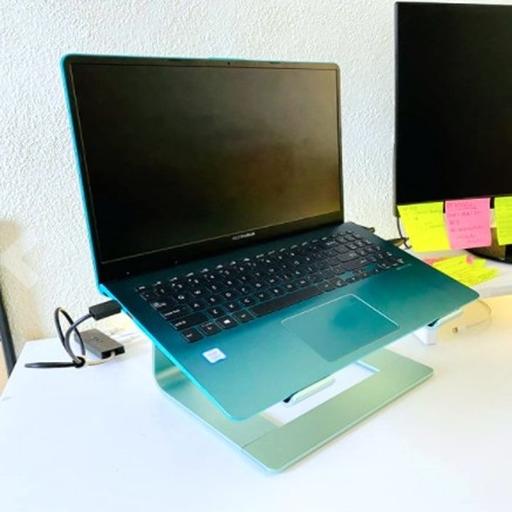 blue laptop elevated on a laptop stand