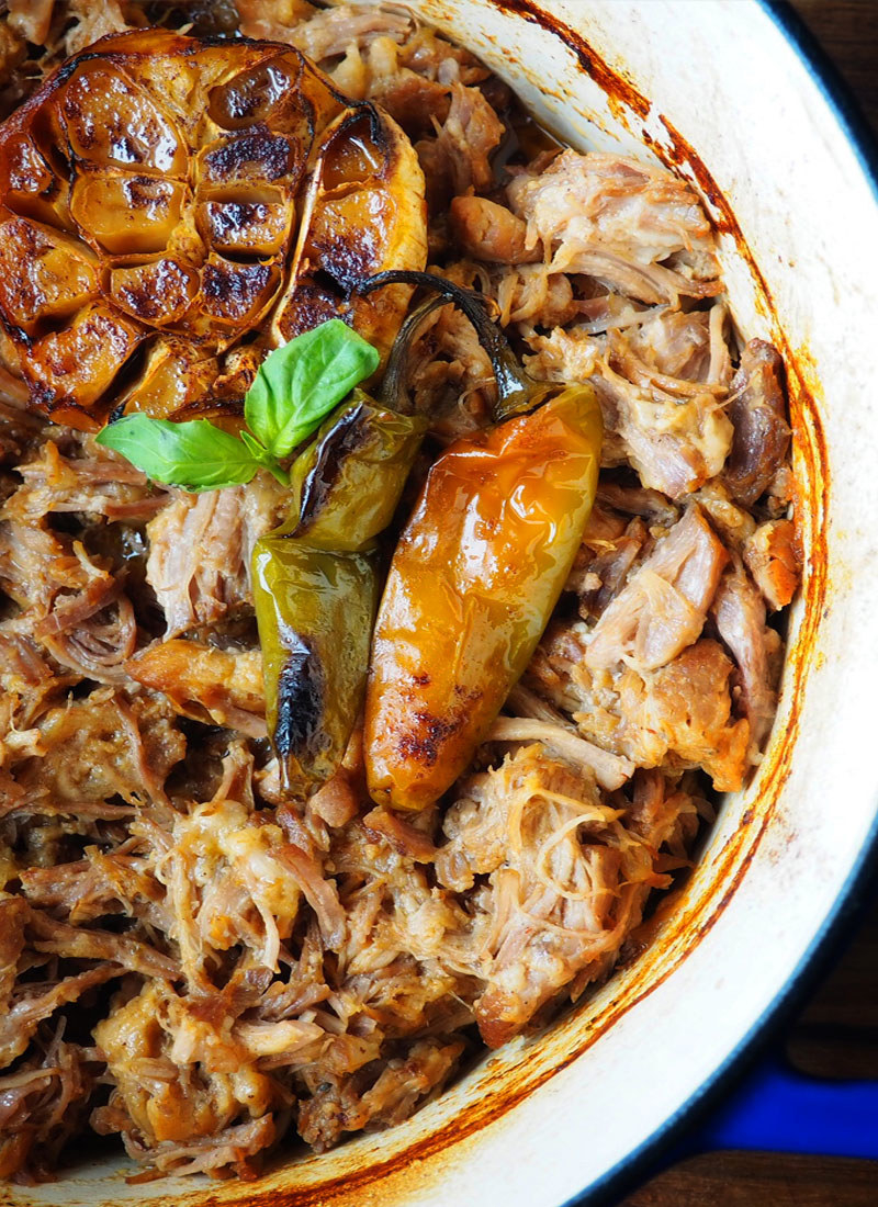 A Dutch oven filled with pork carnitas.
