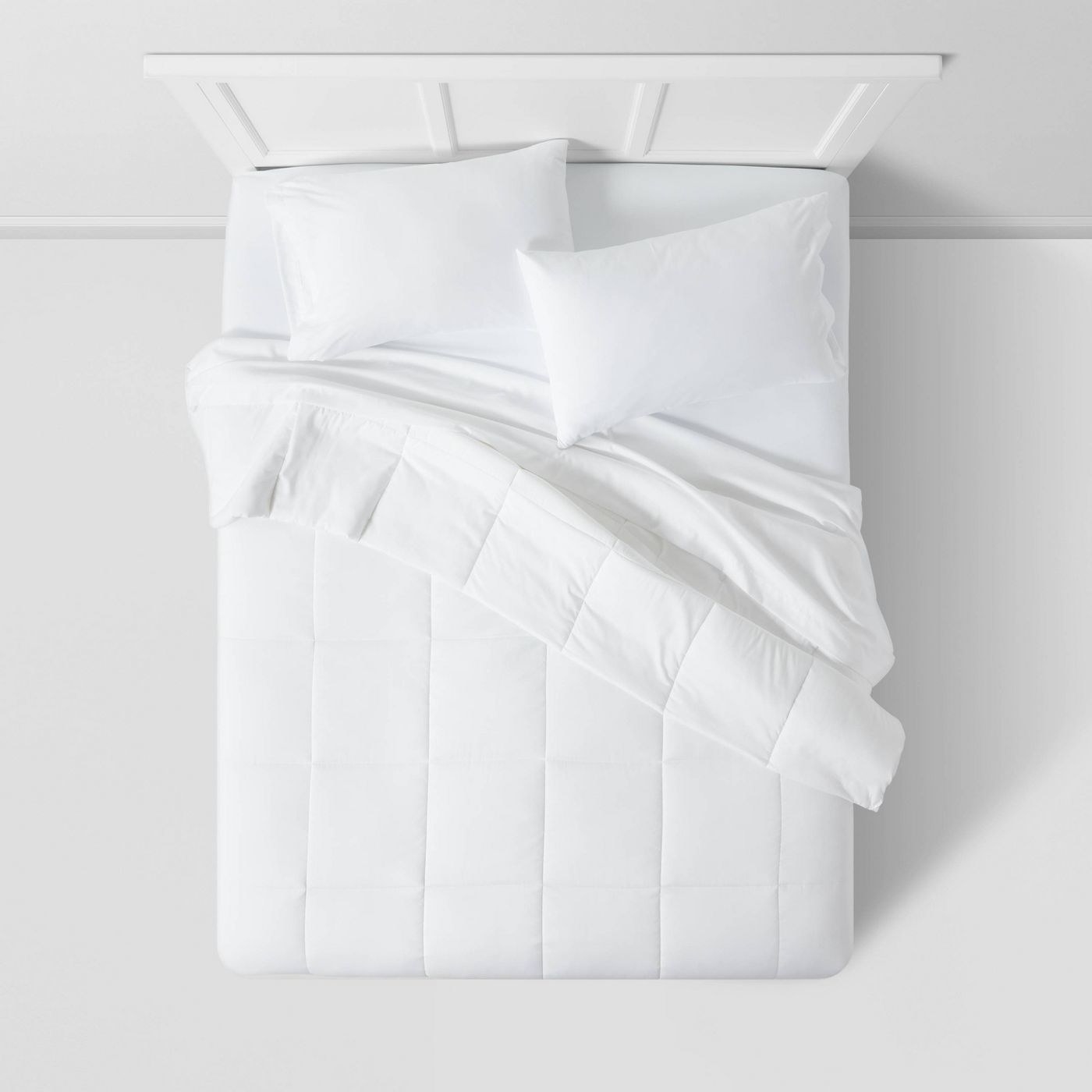 white down alternative comforter on a bed with white pillows and sheets