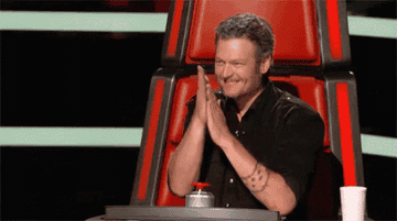 Blake Shelton rubbing his hands together on The Voice