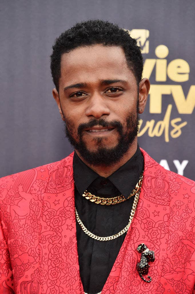 Lakeith Stanfield attends the 2018 MTV Movie And TV Awards a patterned suit and chains