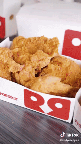A box of Red Rooster fried chicken slides across a table. Then the two boxes of fried chicken, two boxes of chips, three sauces and two Red Rooster paper bags appear.