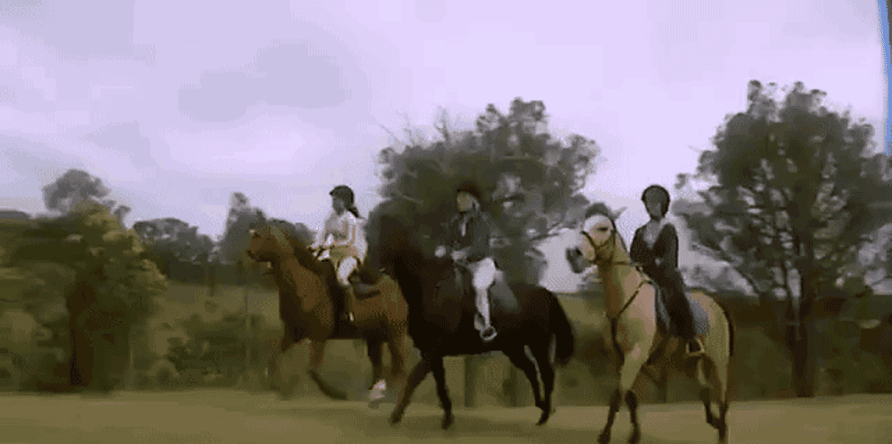 The three main Saddle Club characters on their horses in unison jumping over a dressage jump in the woods 