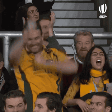 Two people wearing Australian Rugby jerseys fist-pumping and cheering 