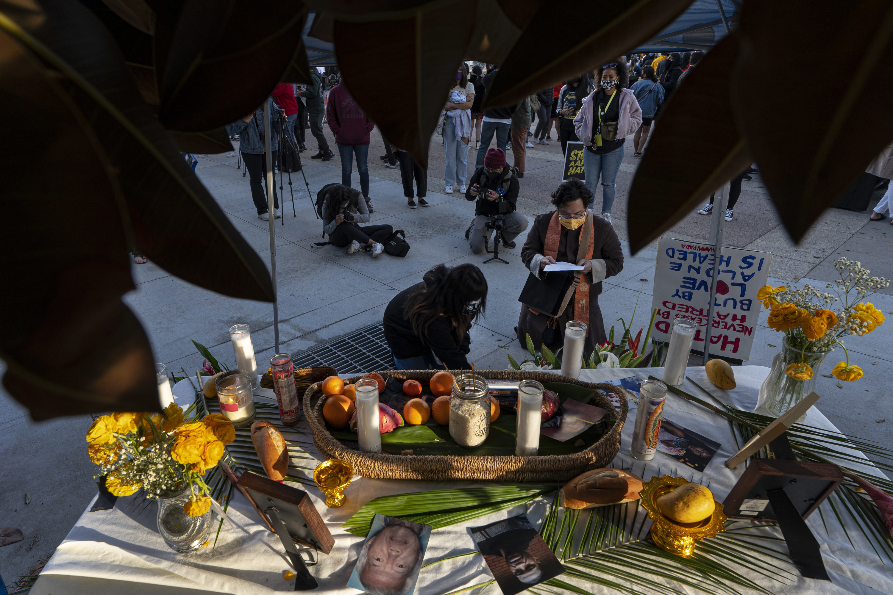 People kneel at an altar for victims of anti-Asian violence