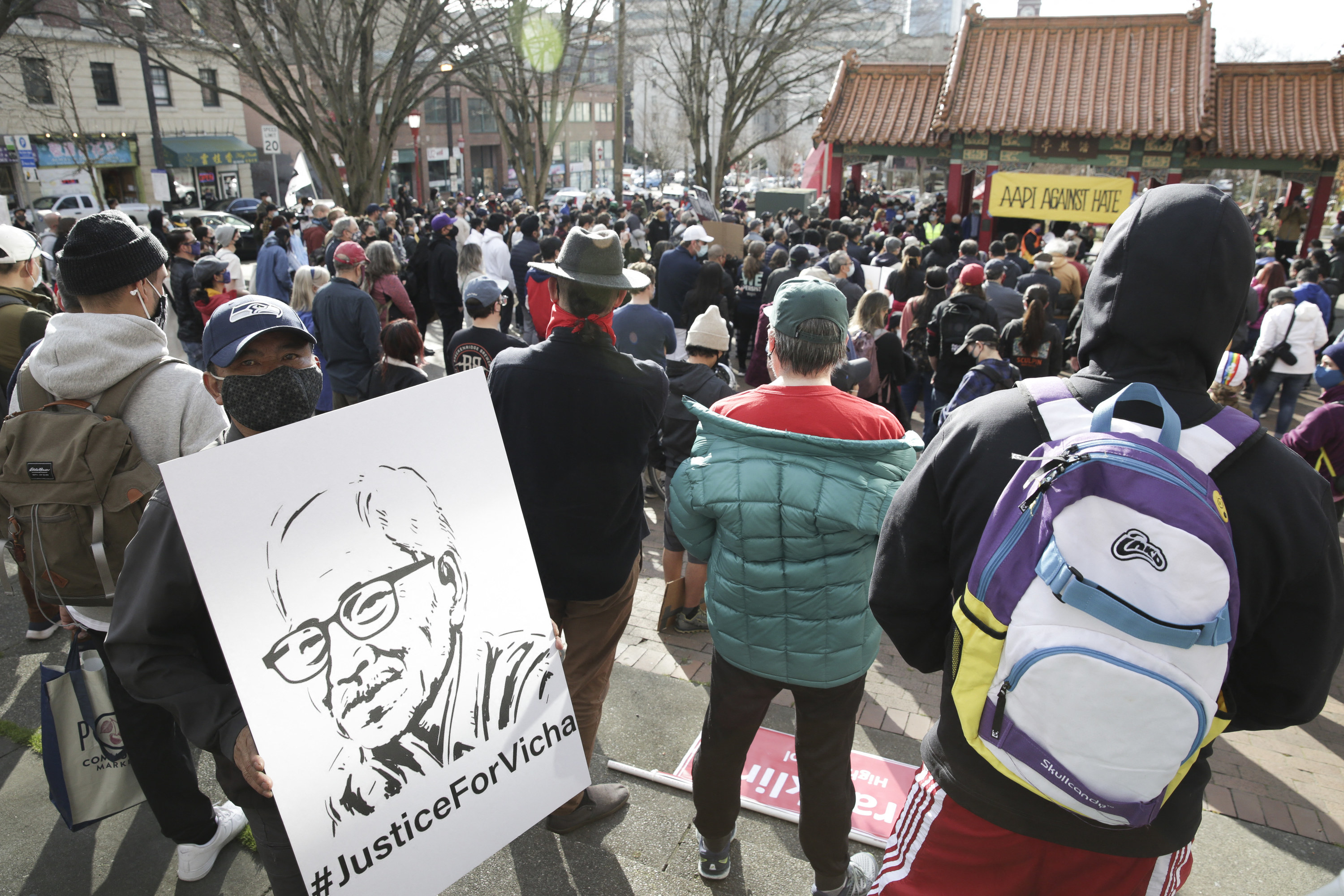 A sign shows a stencil of an older man with the hashtag &quot;#JusticeForVicha&quot;