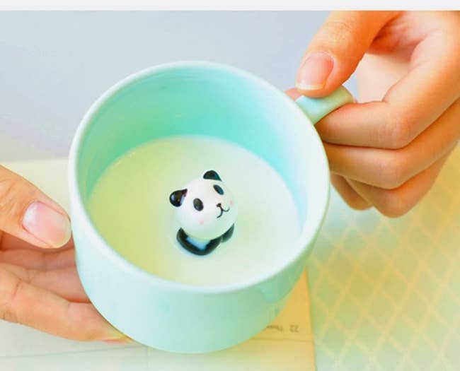 person holding the mug with a panda inside