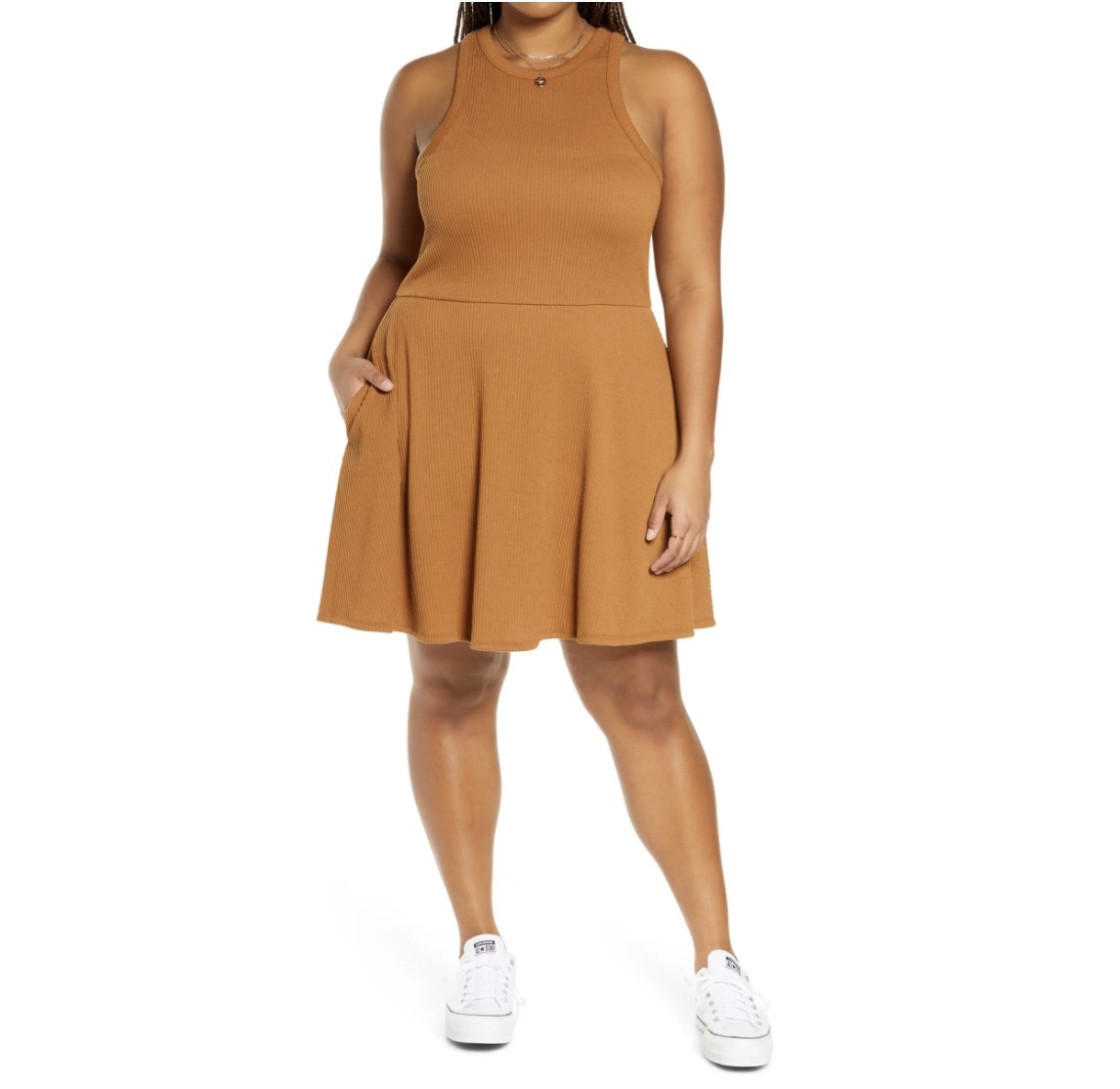 Model is wearing a tan dress and white sneakers