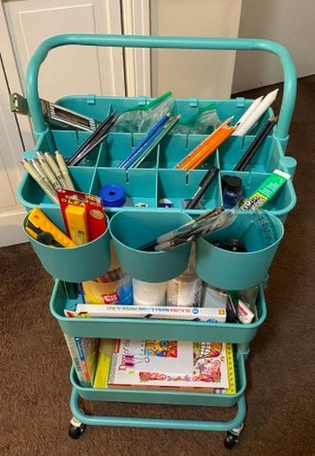 blue utility cart with art supplies in it