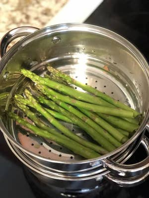 The pot steaming asparagus with the lid off