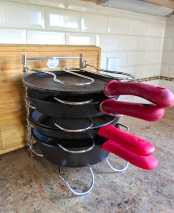 silver rack with cast iron pots on it