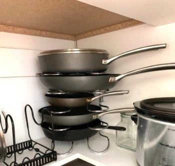 storage rack with gray pots and pans on it