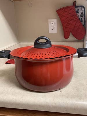 The pot in red on a counter
