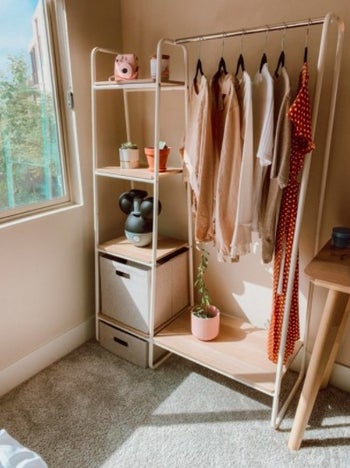 a garment rack with clothes and various items on it