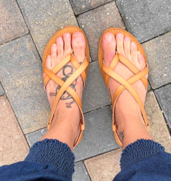 Reviewer wearing the strappy crisscross sandals in tan