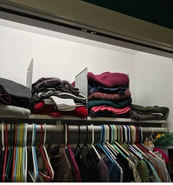 reviewer's top shelf of a closet with stacks of sweaters in between the dividers