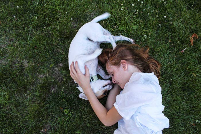Person cuddling with dog outside