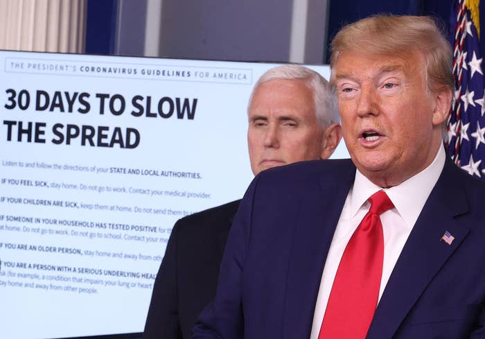 Donald Trump and Mike Pence standing with a screen behind them with the headline &quot;33 Days to Slow the Spread&quot;