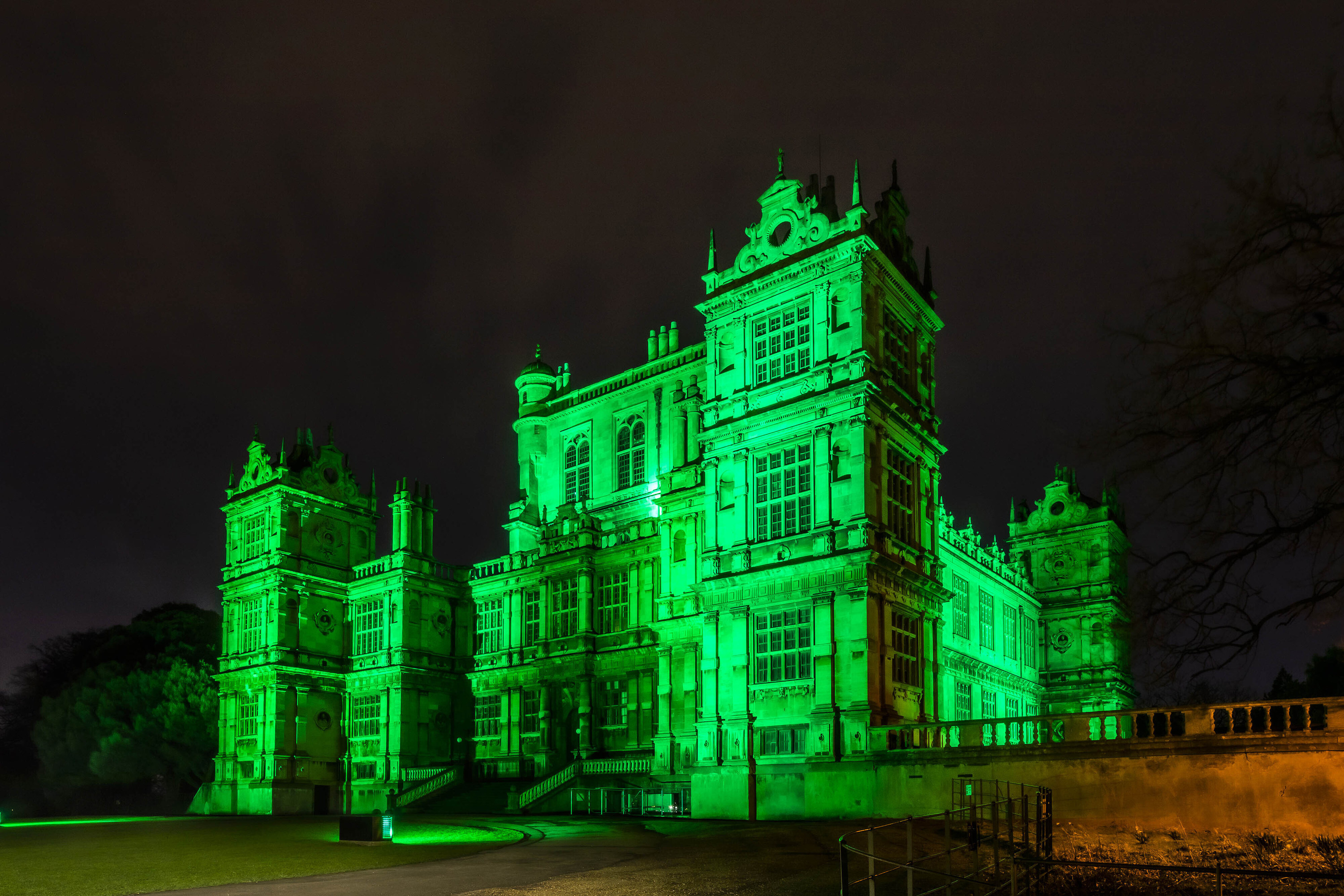 A castle lit up with green lights in honor of St Patricks day