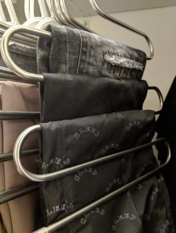 reviewer's s-shaped hanger holding three pairs of pants