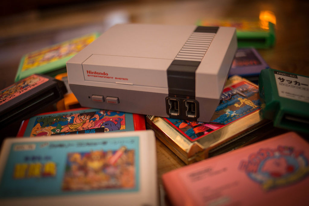 Nintendo Classic Mini &#x27;Nintendo Entertainment System&#x27; video game console first generation seen with a pile of Famicom games cartridges