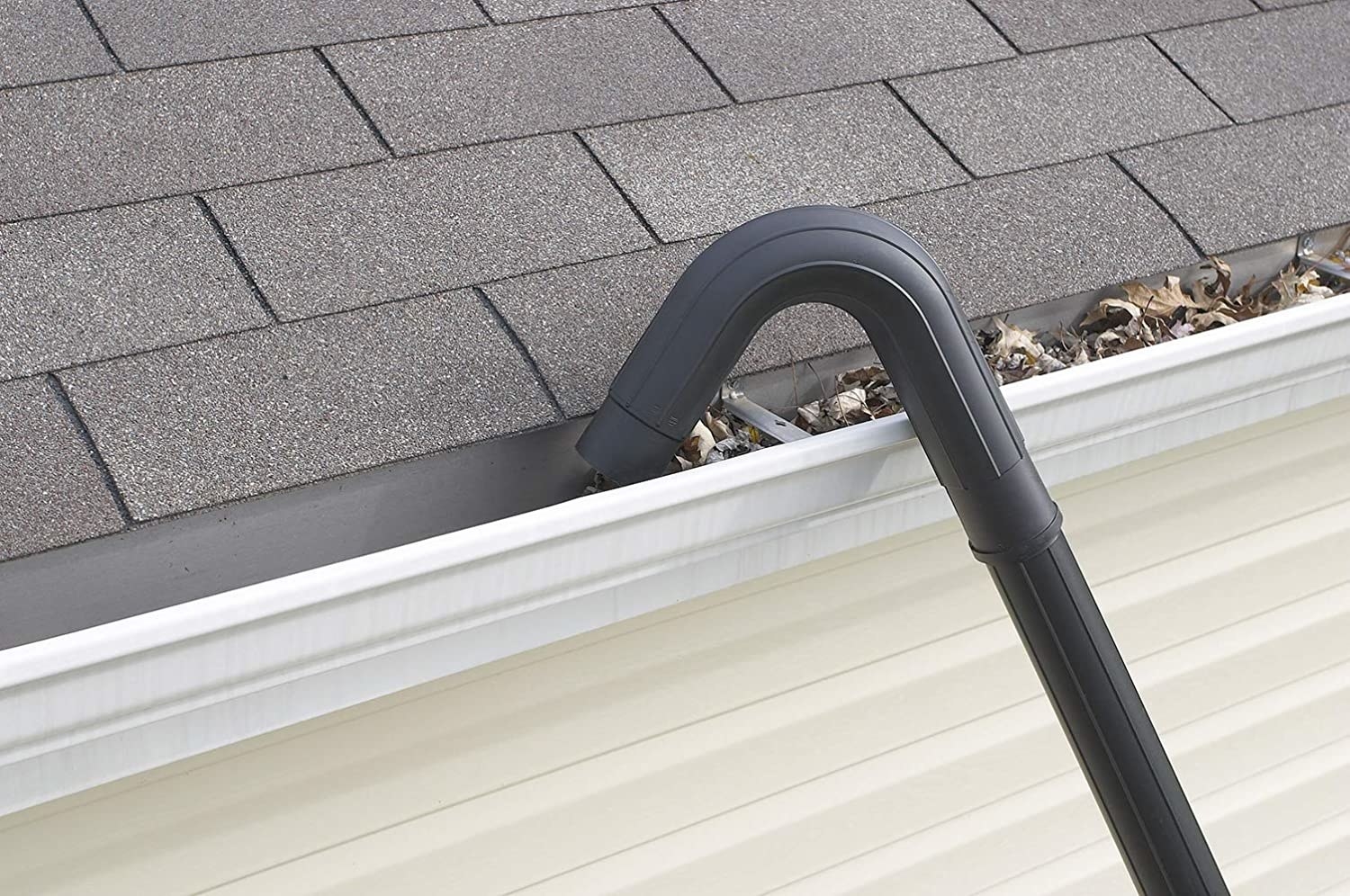 The curved hose sucking up debris inside a gutter