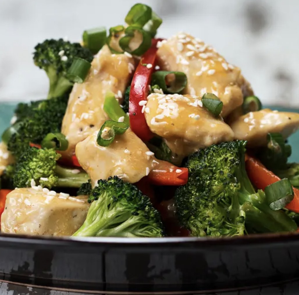 Orange chicken on a bed of broccoli and peppers 