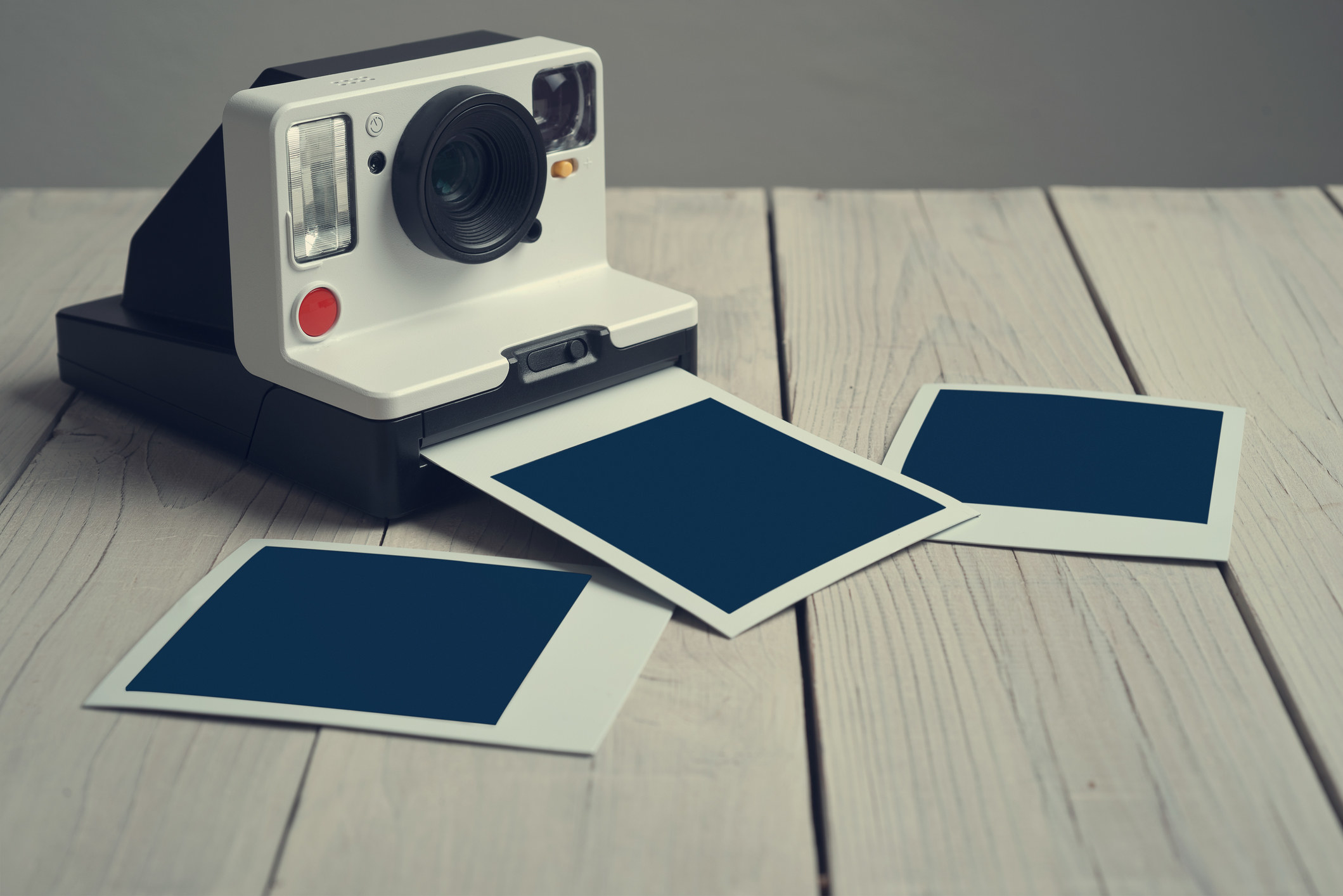 Close-up of polaroid camera and empty prints