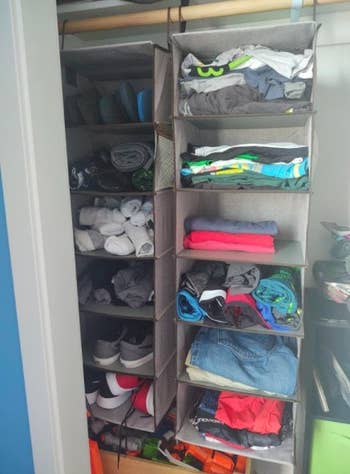two hanging closet organizers with various clothes in them