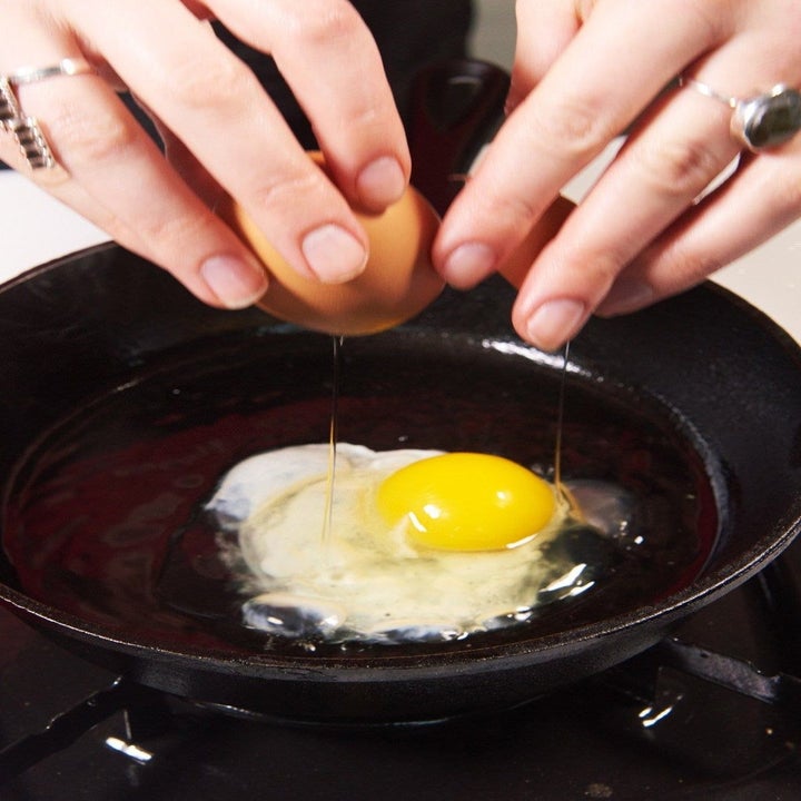 Cracking an egg into a frying pan.