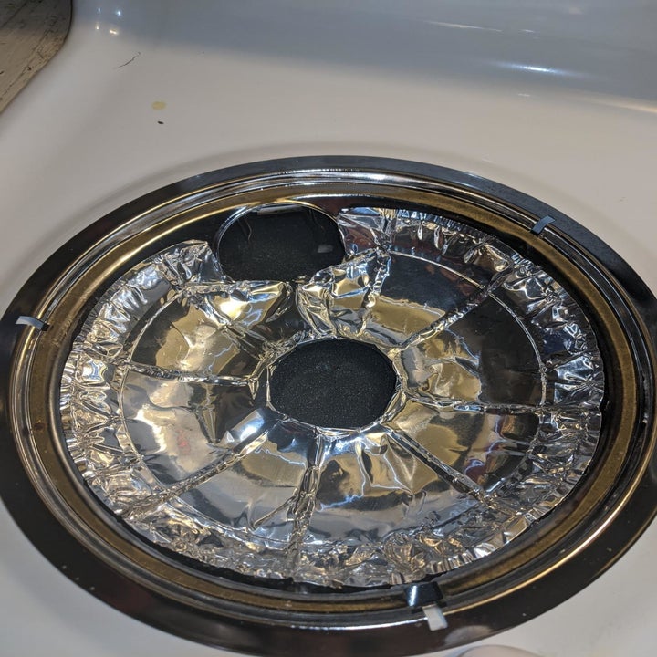 Reviewer photo of Electric Stove Bib Liner placed in drip pan