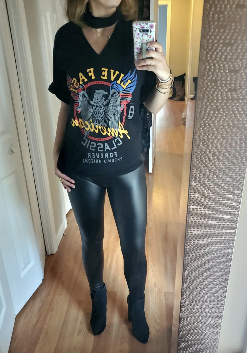 reviewer wearing a band tee and the faux leather leggings 