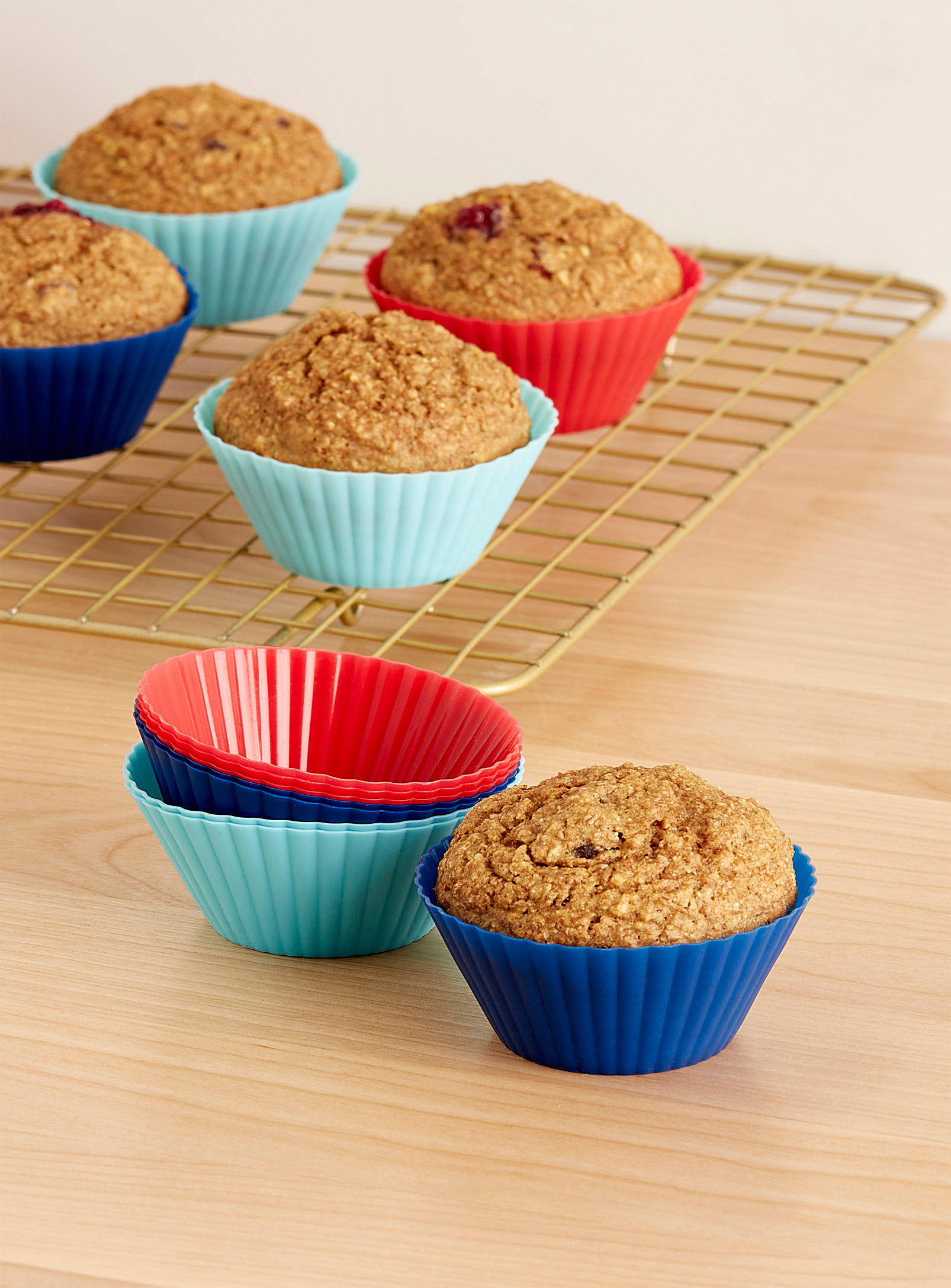A set of silicone muffin moulds on a cooling rack