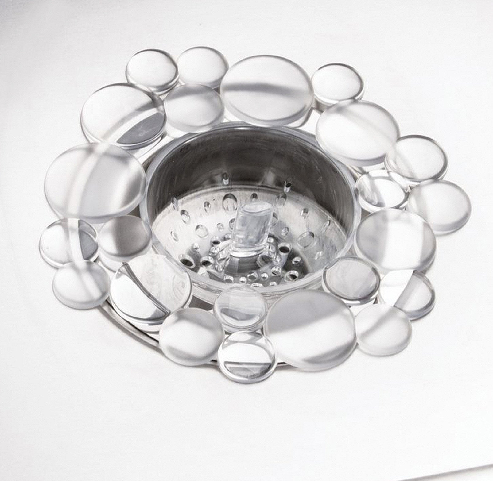 A close up of a transparent sink strainer shaped like bubbles