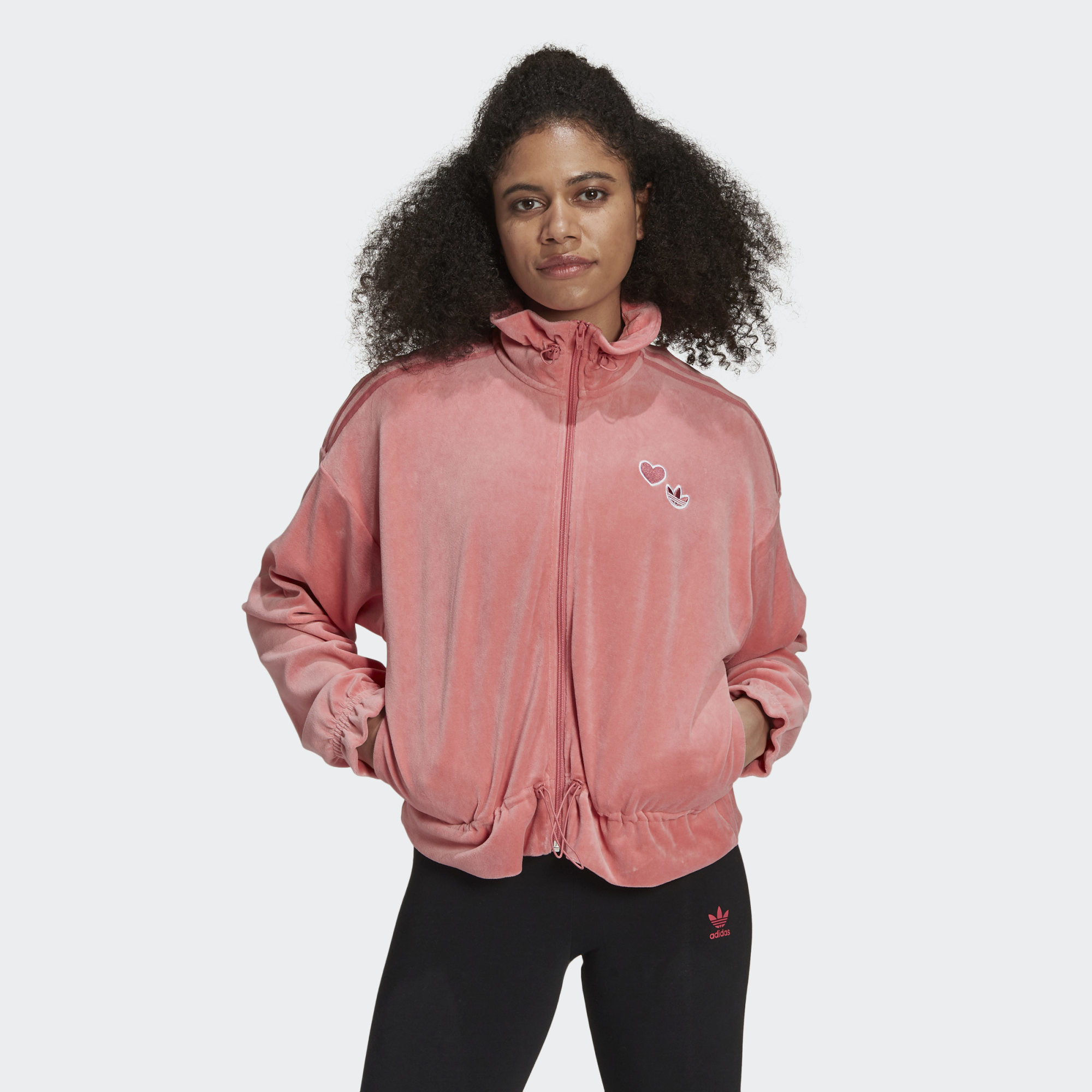 Model wears dusty pink blue velour Adidas zipper jacket with track pants
