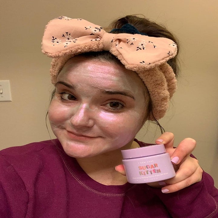reviewer wears same face mask and holds purple container with the formula inside