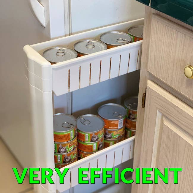 white storage unit holding cans of cat food sliding out from between a fridge and counter, with the text 