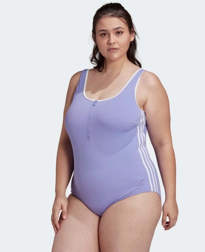 Model wearing purple one piece with white stripes down the side