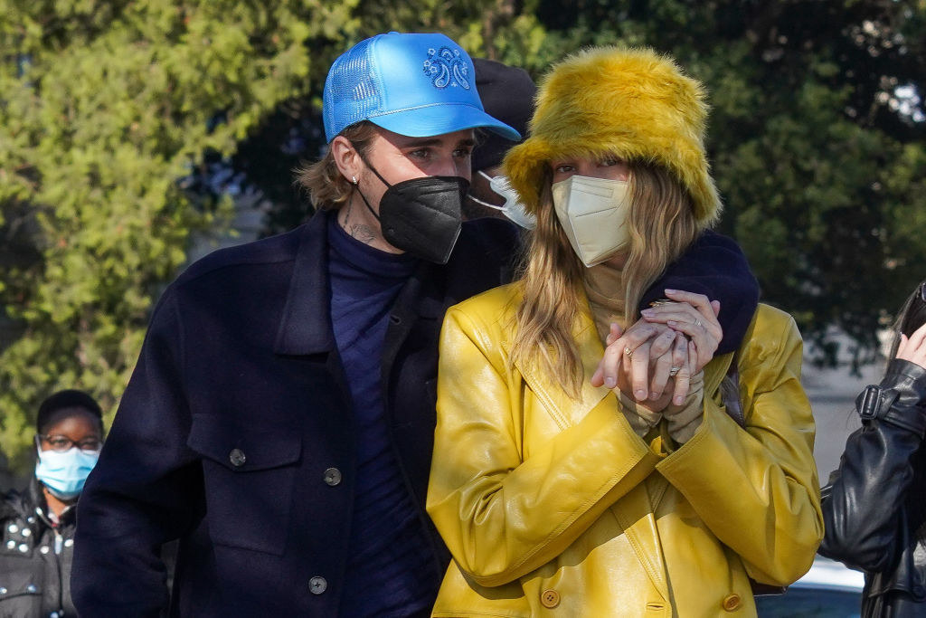 Hailey and Justin walking outside while wearing their face masks