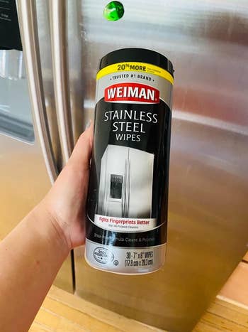 Reviewer holding bottle of Weiman Stainless Steel wipes