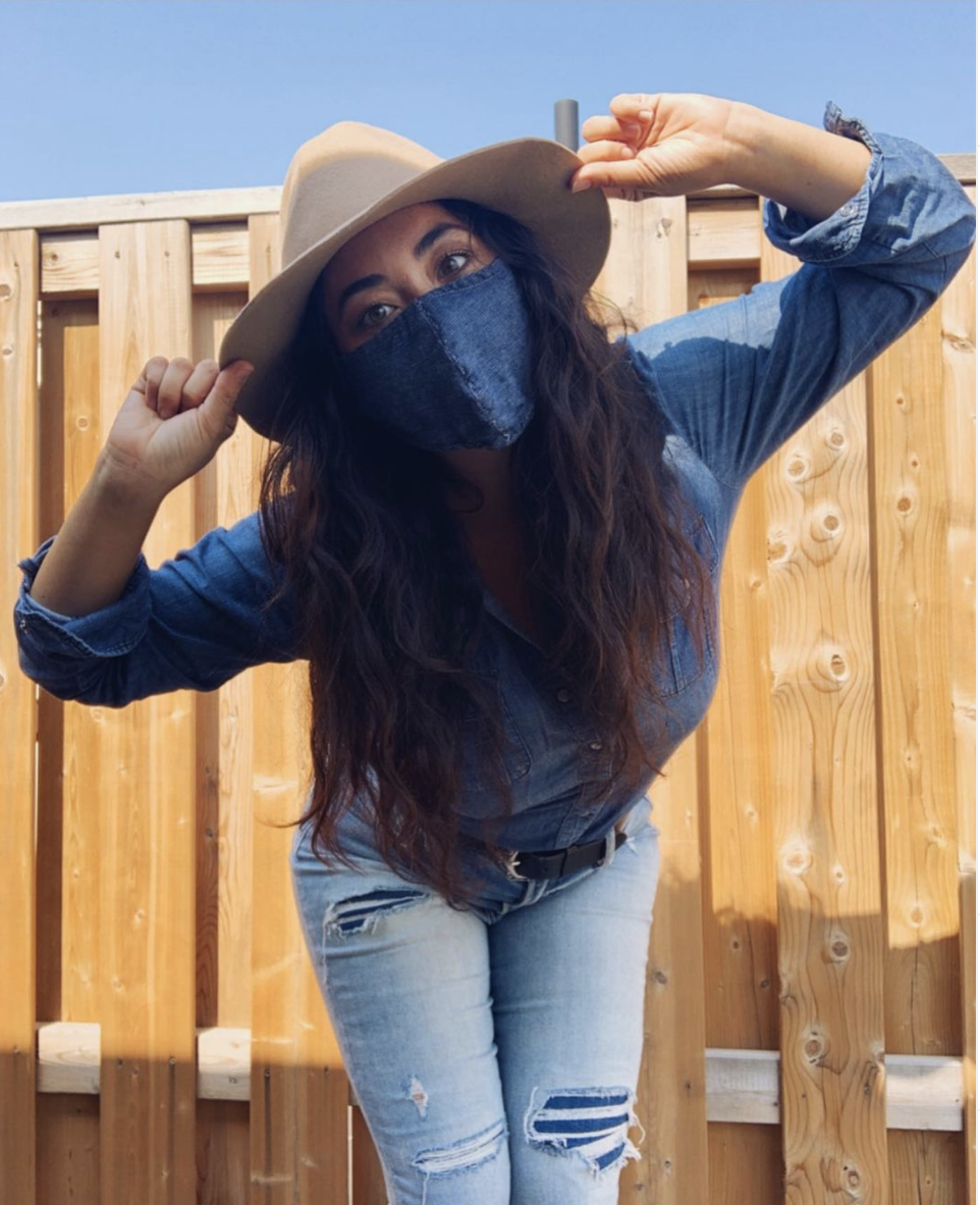 A person wearing a mask made of jean material while wearing blue jeans and a blue shirt.