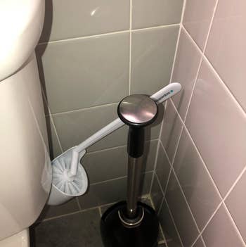 The toilet brush angled out so you can grab it