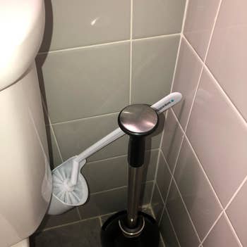 The toilet brush angled out so you can grab it