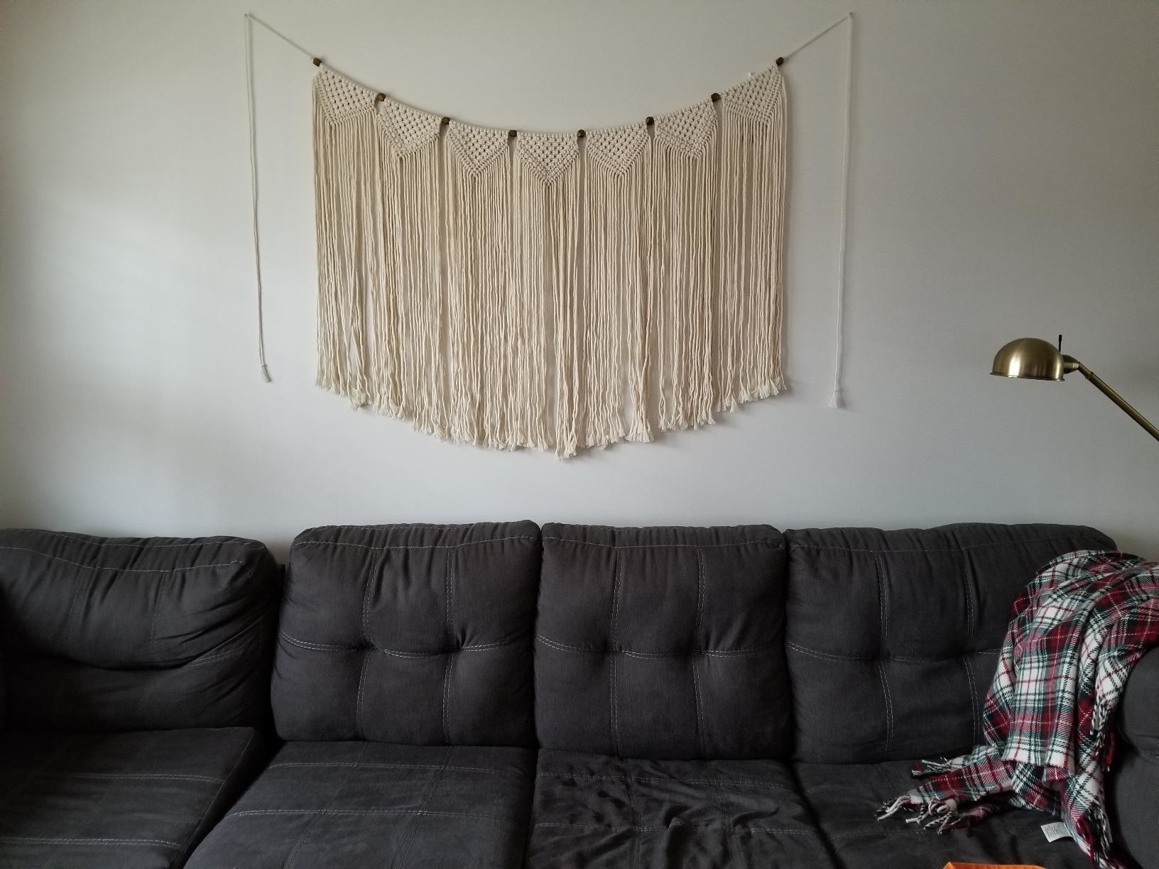 The wall hanging, which is about half the length of a four-seater sofa