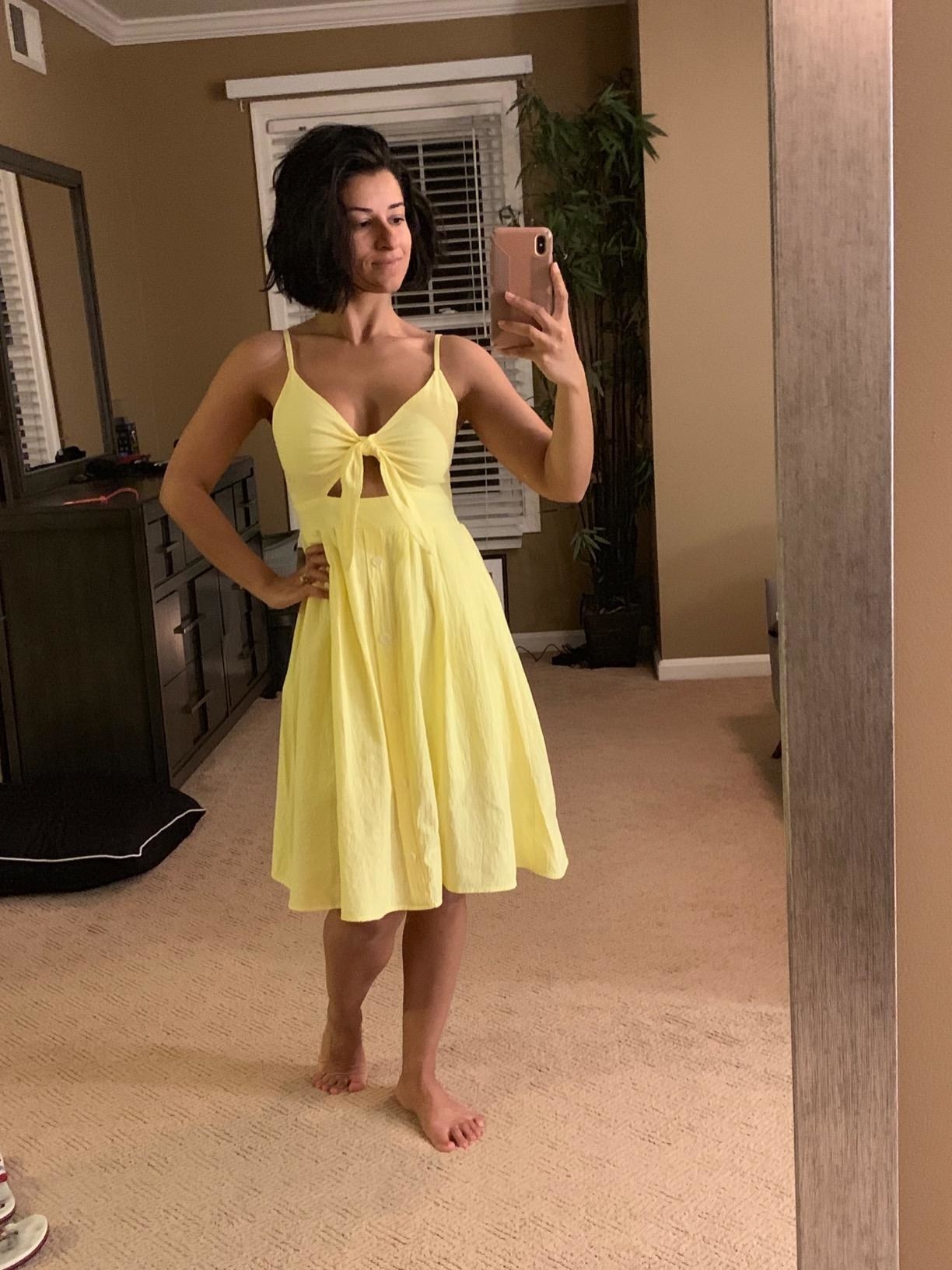 reviewer mirror selfie of them wearing the yellow fancyinn tie front midi dress